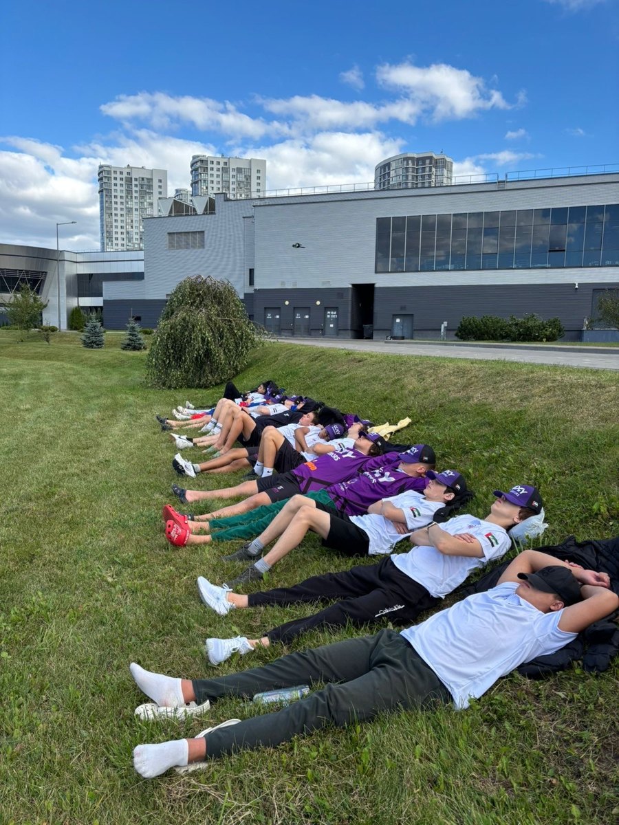 Galaxy players lying on the grass outside the arena in Minsk